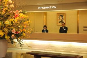 a man and a woman in front of a mirror at Towadako Lake View Hotel in Kosaka