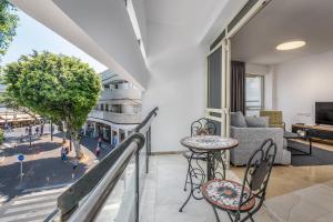 einen Balkon mit einem Tisch, Stühlen und einem Sofa in der Unterkunft DIZENGOFF SQUARE superb 1 bedroom with balcony in Tel Aviv