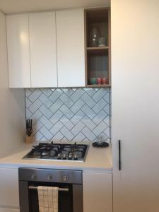 a kitchen with a stove and white cabinets at YARRAVILLE 2 bed 2 bath in Yarraville