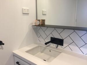 a white bathroom with a sink and a mirror at YARRAVILLE 2 bed 2 bath in Yarraville