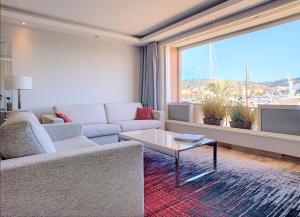 a living room with a couch and a table and a large window at 16 Quai Saint-Pierre in Cannes