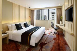 a hotel room with a large bed and a television at Eleven Hotel Bangkok Sukhumvit 11 in Bangkok