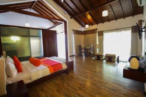 a bedroom with a large bed with orange pillows at The Calm Resort & Spa in Pasikuda