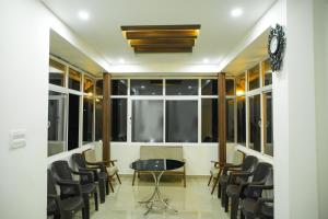 een kamer met stoelen, een tafel en een raam bij Lamond Holidays Munnar in Munnar