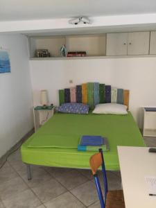 a green bed in a room with a table at studio in old town of Mytilene in Mytilini