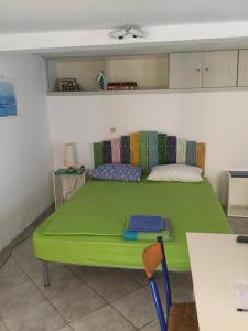 a green bed in a room with a table at studio in old town of Mytilene in Mytilene