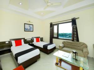 a hotel room with two beds and a couch at Hotel Sanjog International in Amritsar +51 photos