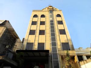 wysoki budynek z oknami i niebieskim niebem w obiekcie Hotel Sanjog International w mieście Amritsar
