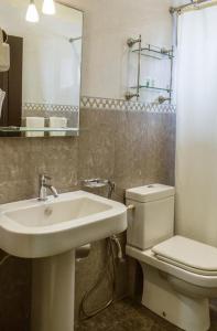 a bathroom with a sink and a toilet and a mirror at Lafala Hotel & Service Apartment in Colombo