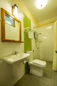 a bathroom with a sink and a toilet and a mirror at Lafala Hotel & Service Apartment in Colombo