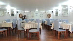 a restaurant with tables and chairs and a person standing in a room at Europa Spa in Trzęsacz