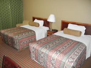 a hotel room with two beds and a lamp at The Surrey Inn in Caldwell