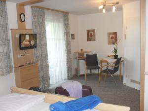 a bedroom with a bed and a table and chairs at Landhaus Brummer in Bad Birnbach