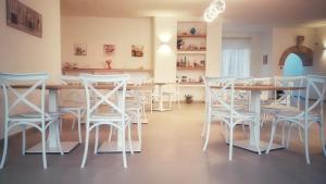 comedor con mesa y sillas blancas en Villa Minerva Family Relais, en Alezio