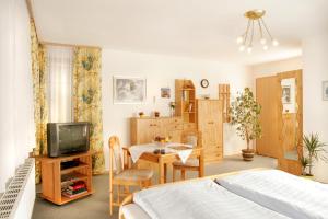 a bedroom with a bed and a table and a tv at Landhaus Brummer in Bad Birnbach