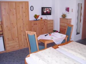 a room with a table and two chairs and a bedroom at Landhaus Brummer in Bad Birnbach +7 photos
