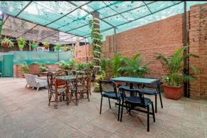 eine Terrasse mit Tischen und Stühlen in einem Gewächshaus in der Unterkunft Hotel Arma Residency in Mumbai