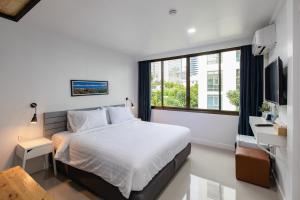 a bedroom with a bed and a large window at Every Surawong in Bangkok