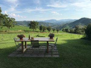 a picnic table with two chairs and a view of a field at Paradiso di Sara in Vignale