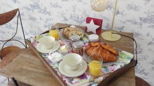 a tray of food with croissants and orange juice on a table at Ganamapa in Merlimont
