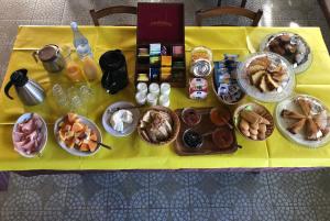 una mesa con platos de comida en un mantel amarillo en Agriturismo Su Meurreddu, en Tratalias