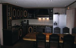 a kitchen with a table and a white refrigerator at Amazing Home In Hemsedal With 7 Bedrooms, Sauna And Wifi in Hemsedal