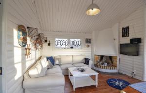 a living room with a white couch and a tv at Cozy Home In Ånimskog in Ånimskog +11 photos