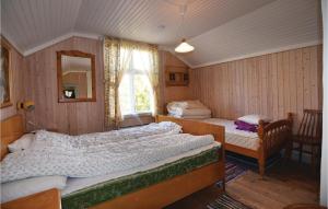 オーリェングにあるAmazing Home In rjng With 4 Bedrooms And Wifiのベッドルーム1室(ベッド2台、鏡、窓付)