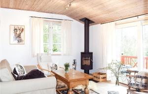 uma sala de estar com um fogão a lenha em Awesome Home In Knred With House A Panoramic View em Knäred
