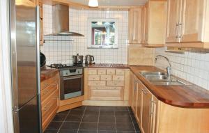 cocina con armarios de madera y nevera de acero inoxidable en Awesome Home In Sffle With House Sea View, en Harnäs