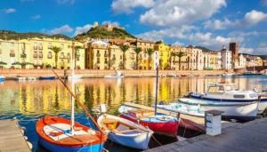a group of boats docked in a harbor with buildings at Bosa Exclusive Apartments "Bosa Apartments" in Bosa