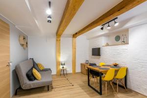 ein Wohnzimmer mit einem Tisch und gelben Stühlen in der Unterkunft All Season Studios in Braşov