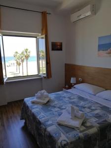 sypialnia z 2 łóżkami i widokiem na plażę w obiekcie B&B Altamarea w mieście Marina di Schiavonea