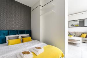 Un dormitorio con una cama amarilla y blanca y un sofá en Gama en Varsovia