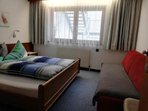 een slaapkamer met een bed, een bank en een raam bij Garni Raphaela in Sölden