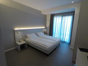 Hotel Paradiso في باردولينو: غرفه فندقيه بسرير ونافذه