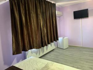 a room with a bed and a curtain at Marisol in Eforie Nord