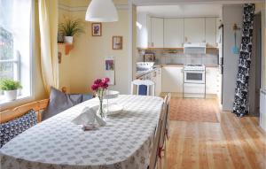 a kitchen and dining room with a table with flowers on it at Nice Home In Bruzaholm With Kitchen in Bruzaholm