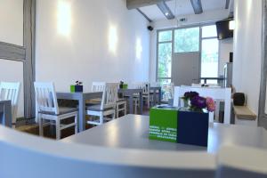 Pension Typisch Naumburg في ناومبورغ: غرفة طعام مع طاولات وكراسي بيضاء