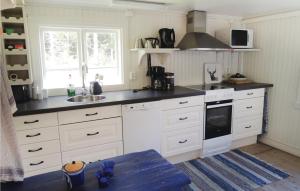 a kitchen with white cabinets and a sink at Awesome Home In Lammhult With Kitchen in Asaryd