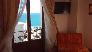 um quarto com uma porta com vista para o oceano em B&B Celestina Peschici em Peschici