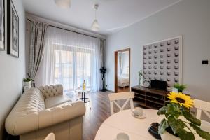 a living room with a couch and a table at Angels Home Toruń in Toruń