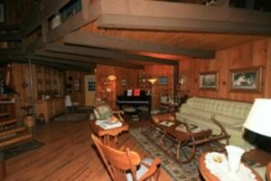 a living room with a couch and a piano at Stouffermill Bed & Breakfast in Algonquin Highlands