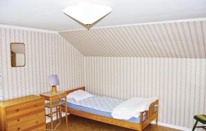 LinnerydにあるBeautiful Home In Linneryd With Kitchenのベッドルーム1室(ベッド1台、ドレッサー、ランプ付)