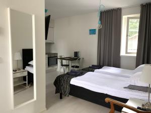 1 dormitorio con cama, mesa y espejo en Green Door Apartments en Jyväskylä