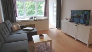 a living room with a couch and a flat screen tv at City Apartment Bahnhofnah in Kiel
