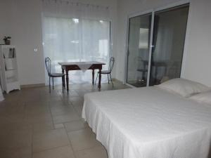 - une chambre avec un lit, une table et des chaises dans l'établissement L'EPICERIE, à Pau