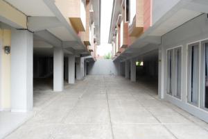 an empty hallway of a building with white columns at RedDoorz Syariah near RSUD Margono Purwokerto in Purwokerto