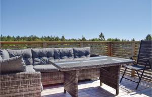 a patio with a couch and a table and chairs at Four-Bedroom Holiday Home In Sondeled in Søndeled