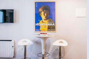 a table with two stools and a poster on the wall at Cozy and perfect location Bairro Alto Chiado in Lisbon